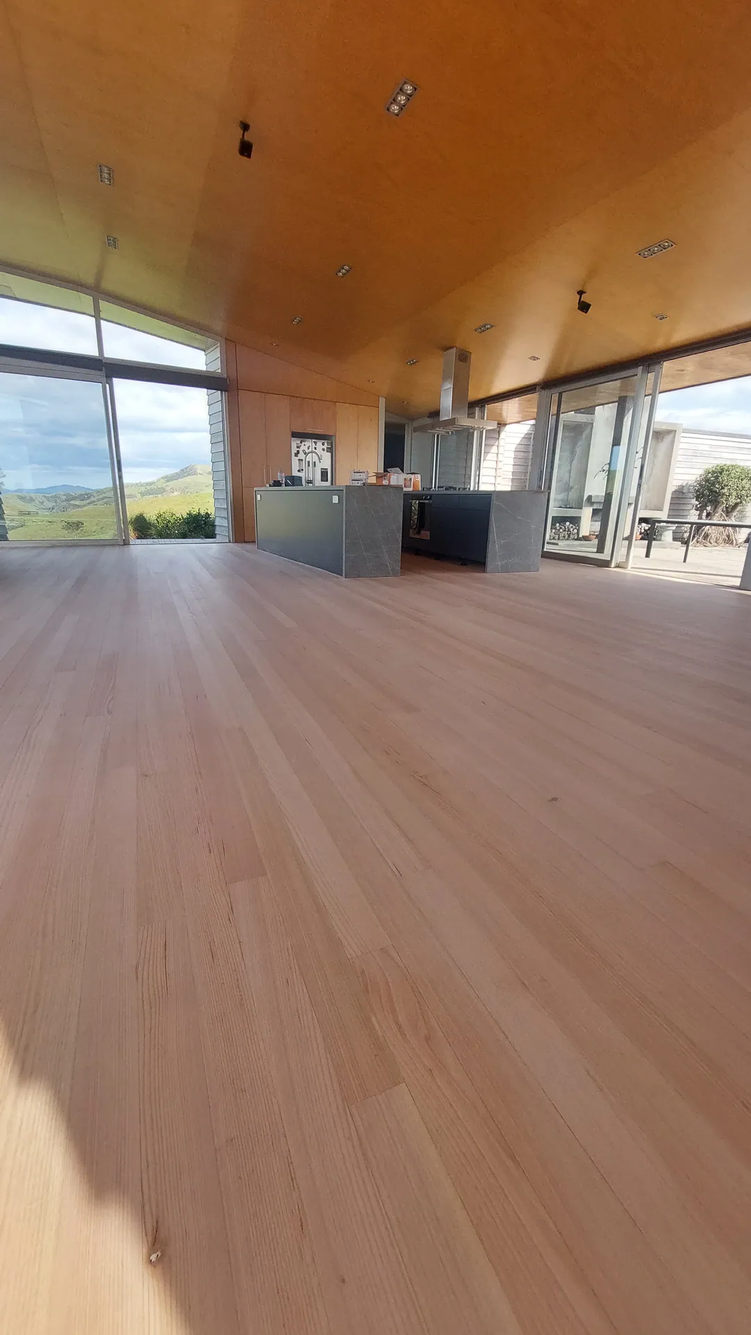 Blond timber floor through an open-plan home.