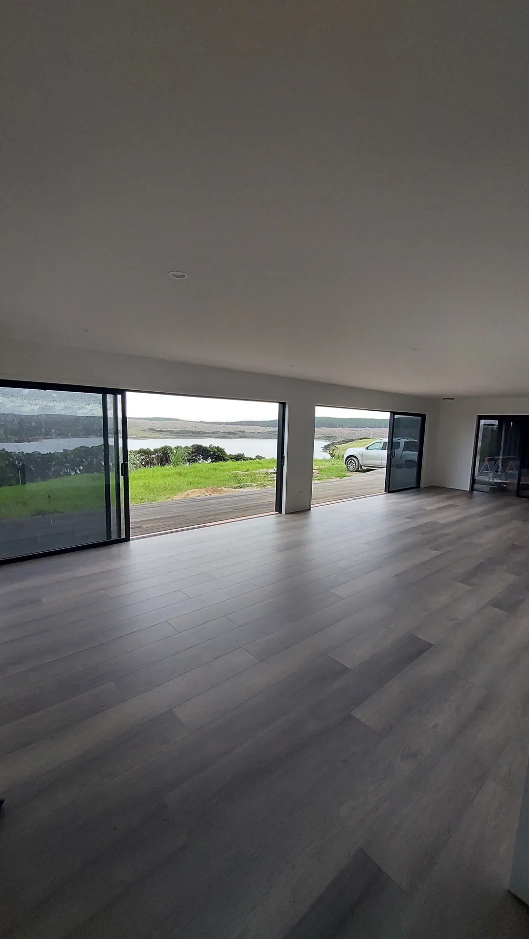Dark grey floor out to a water view.