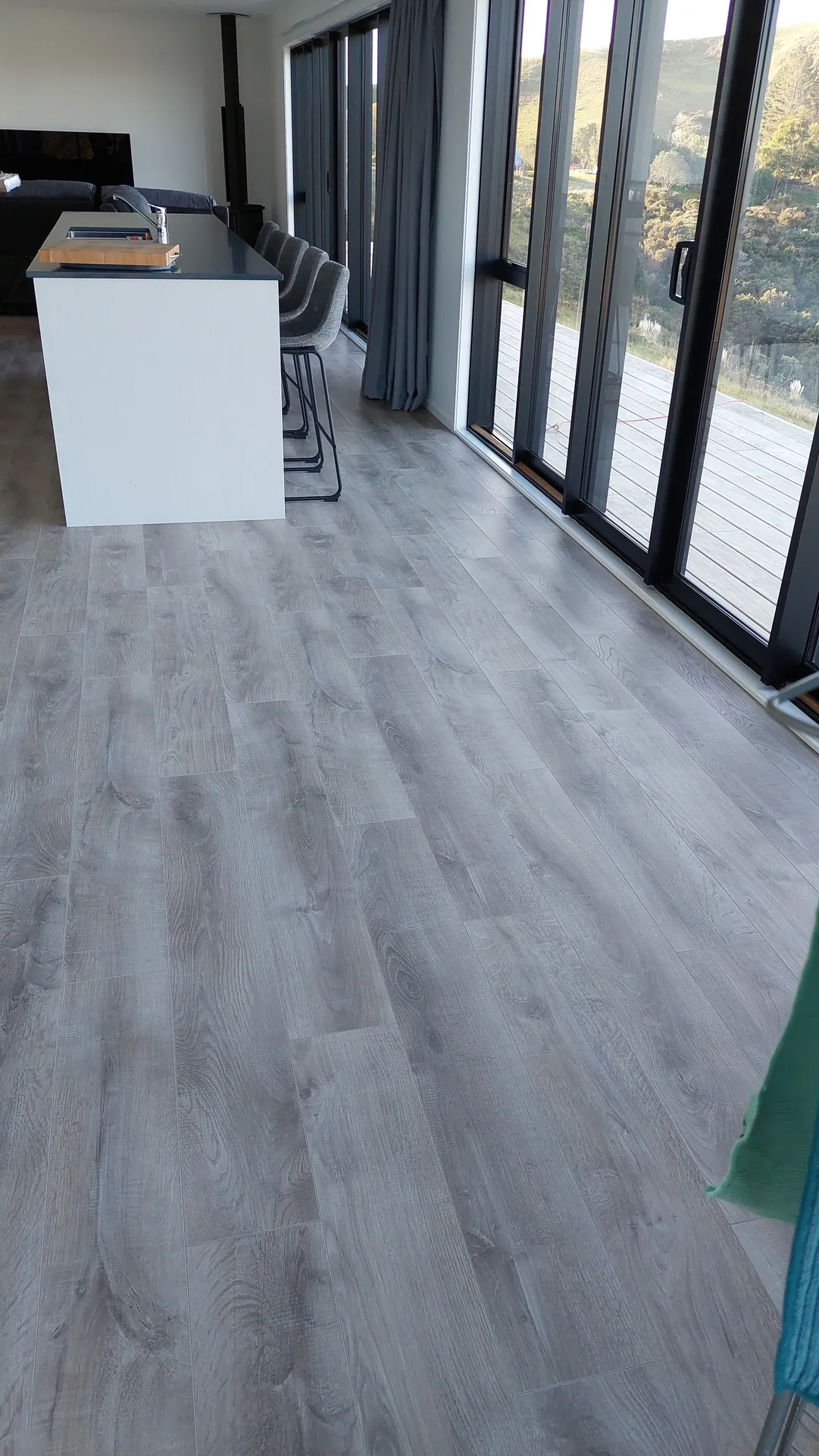 Grey floor along a kitchen with sea views.