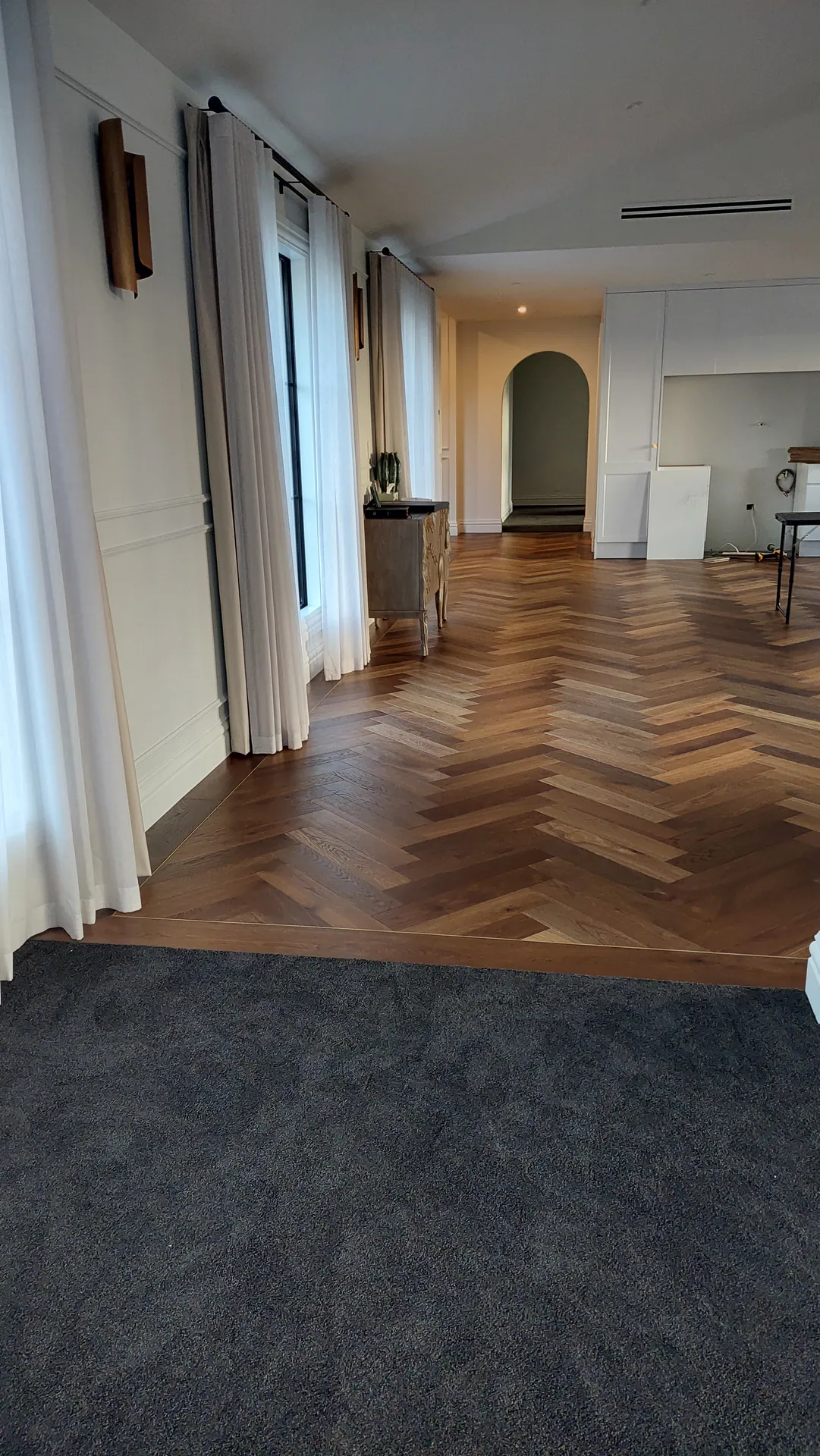 Herringbone hallway to an arched doorway.