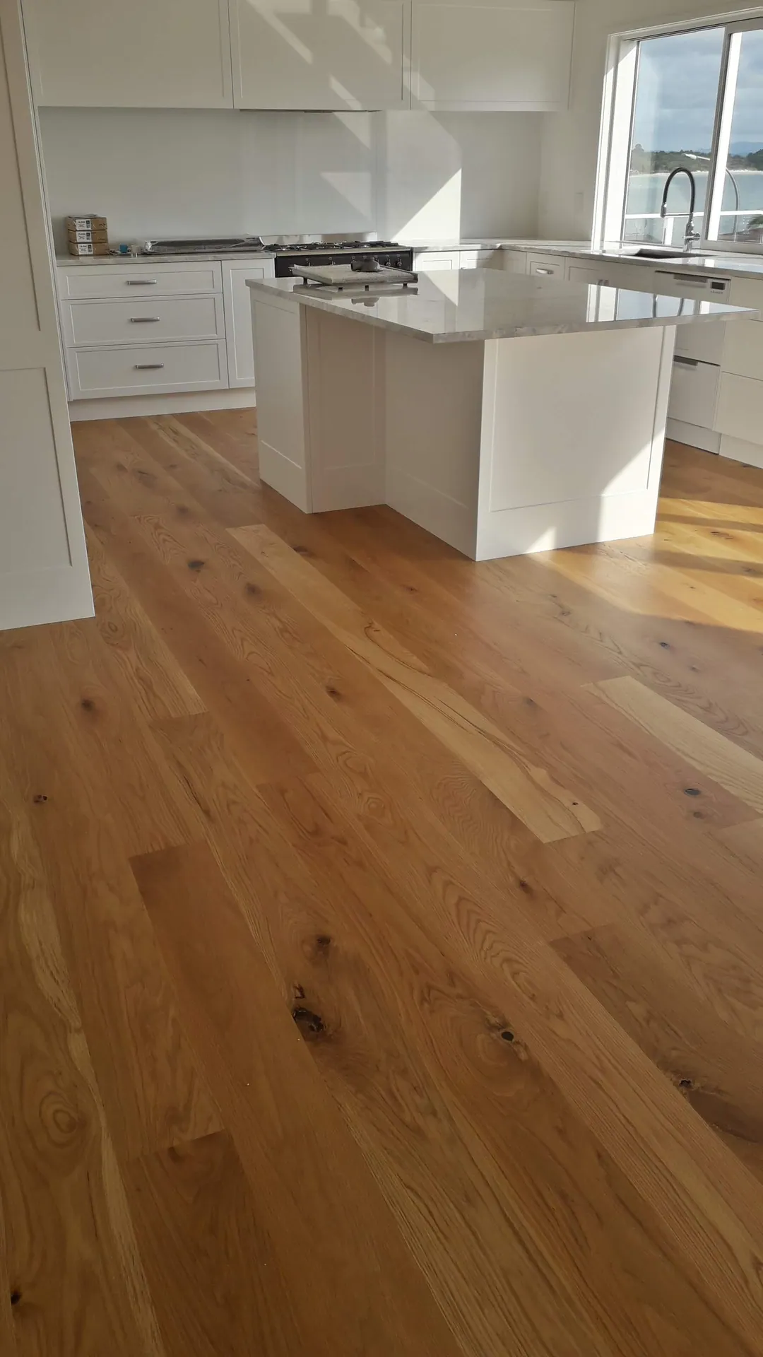Oak floor around a white kitchen island.