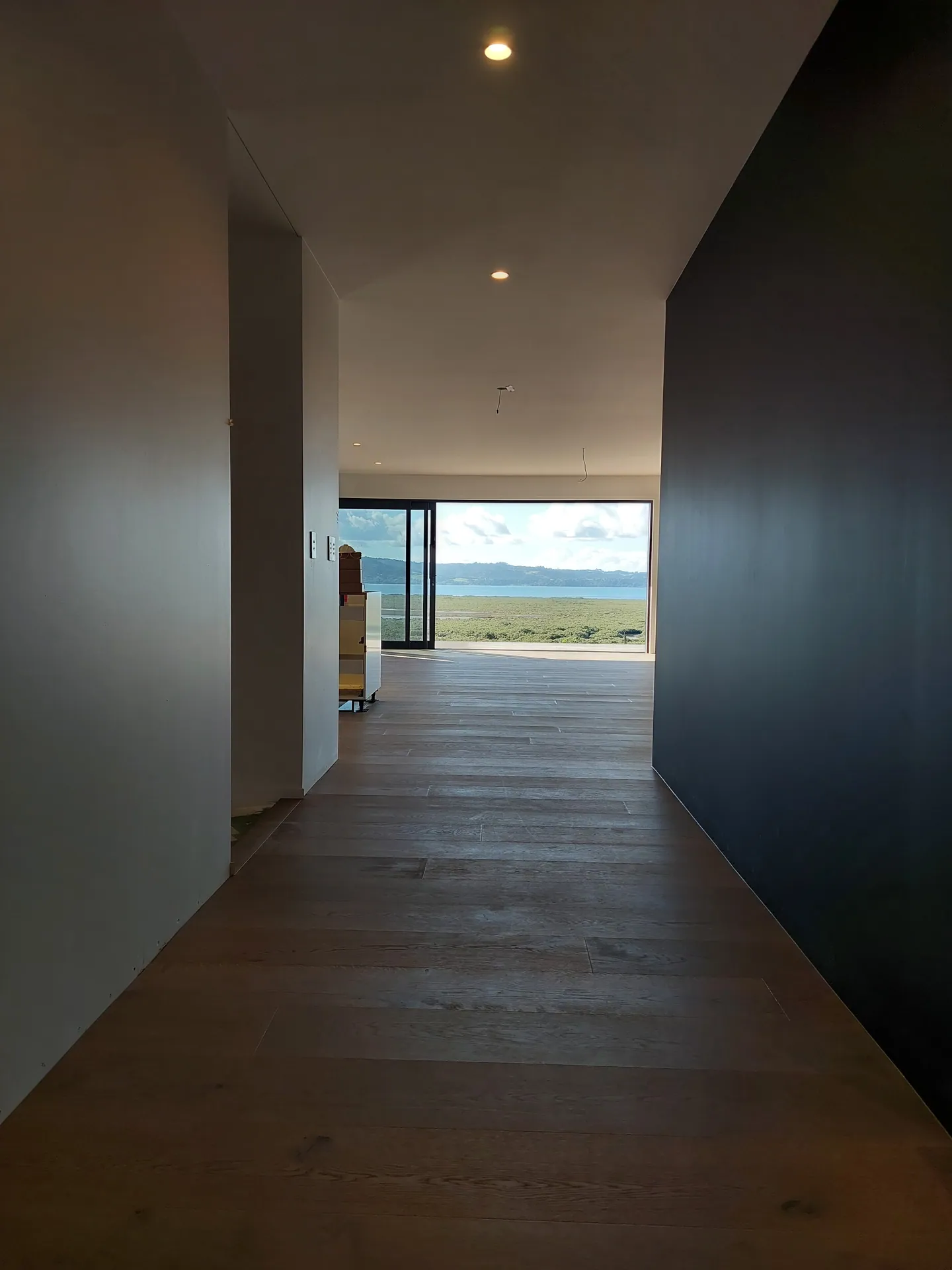 Oak floor down a hallway to a view.