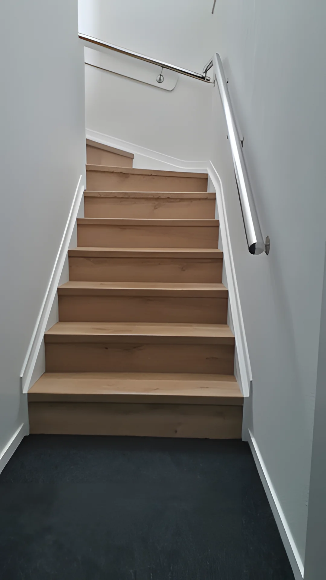 Timber stair treads with a chrome handrail.